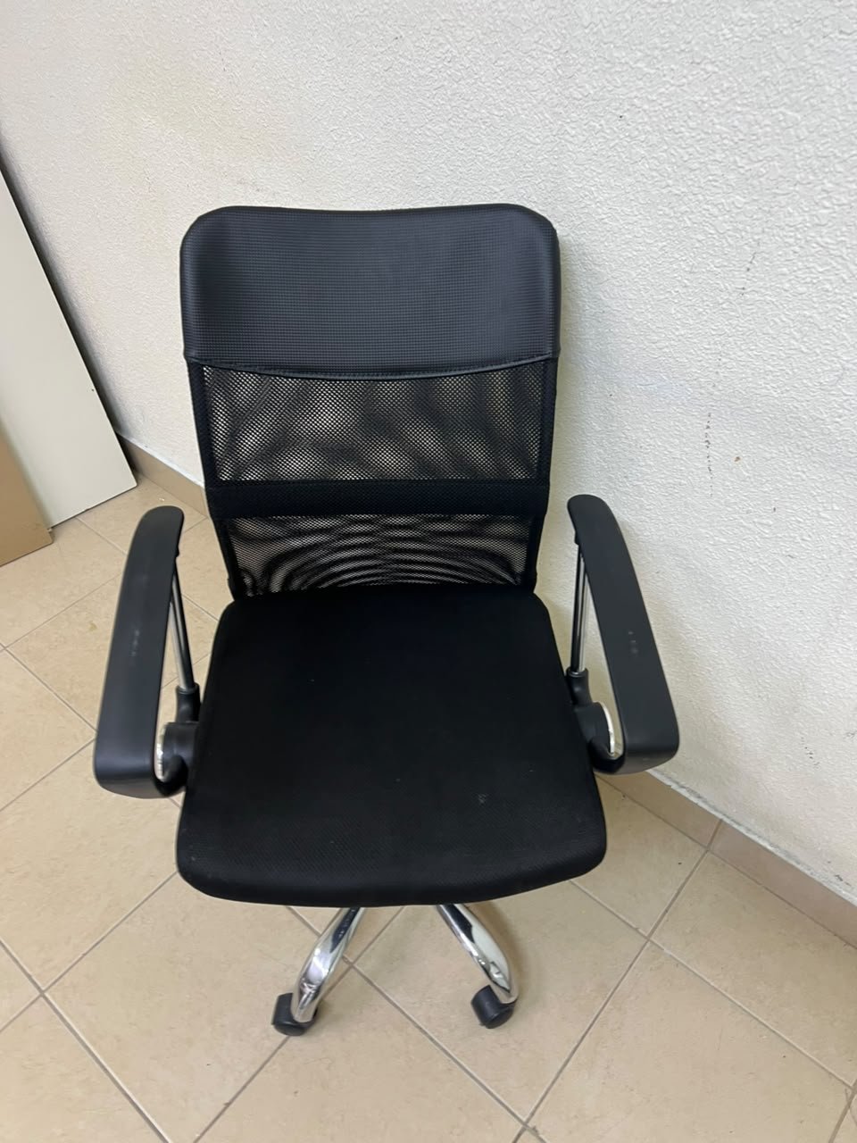 A black office chair featuring a comfortable mesh back, a chrome metal base with casters, armrests, and adjustable height. - Image 2