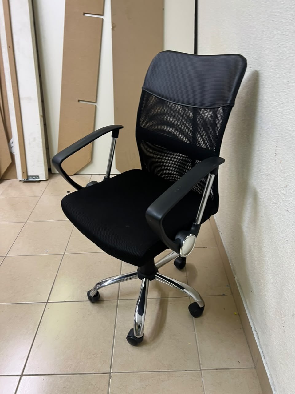 A black office chair featuring a comfortable mesh back, a chrome metal base with casters, armrests, and adjustable height. - Image 3