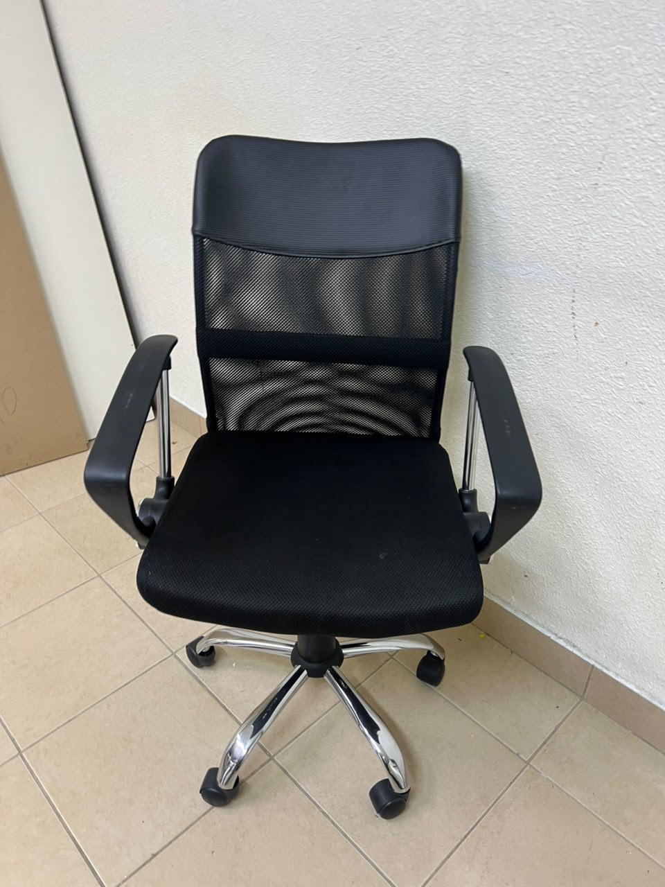 A black office chair featuring a comfortable mesh back, a chrome metal base with casters, armrests, and adjustable height. - Image 5