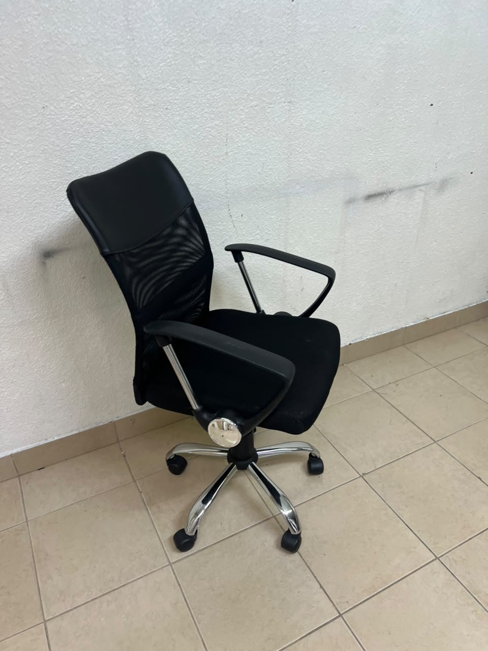 A black office chair featuring a comfortable mesh back, a chrome metal base with casters, armrests, and adjustable height. - Image 6