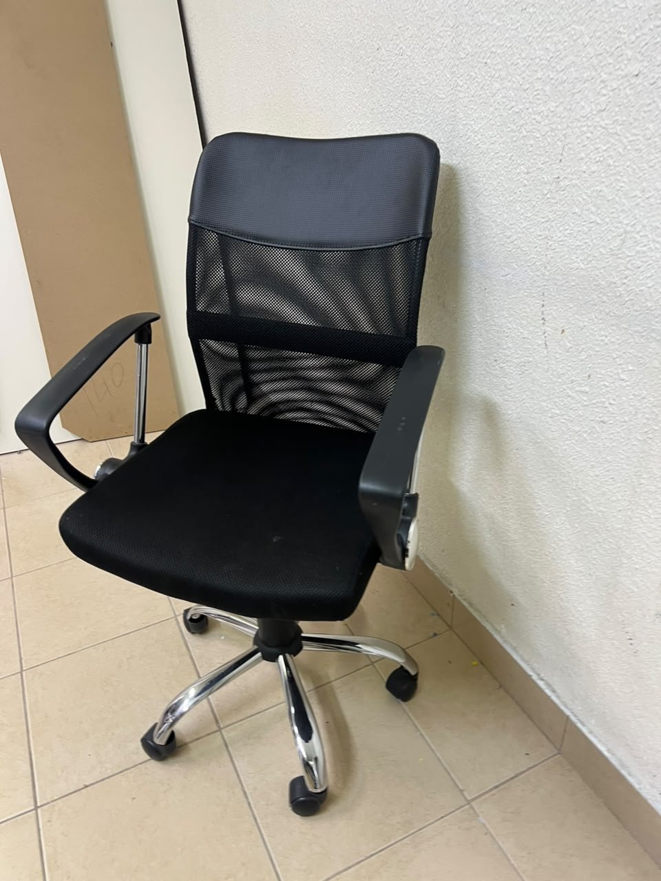 A black office chair featuring a comfortable mesh back, a chrome metal base with casters, armrests, and adjustable height. - Image 7