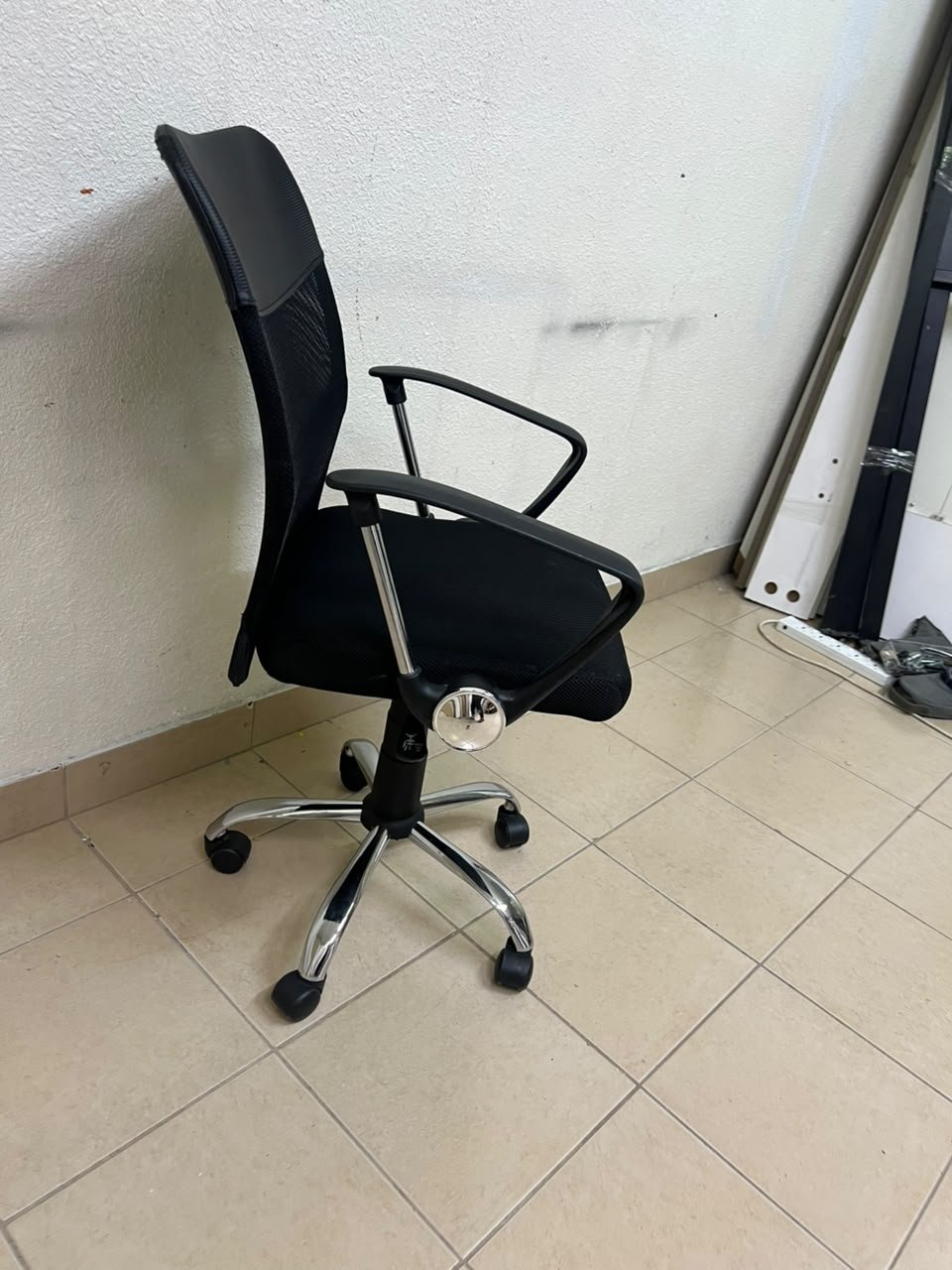 A black office chair featuring a comfortable mesh back, a chrome metal base with casters, armrests, and adjustable height. - Image 8