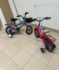 Two children’s bicycles in different colors (blue and red), equipped with training wheels and front baskets. - Image 5