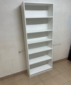 A white bookcase that looks similar to an IKEA BILLY bookcase or other comparable multi-shelf storage units.