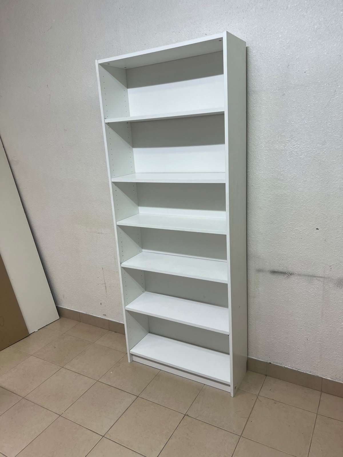 A white bookcase that looks similar to an IKEA BILLY bookcase or other comparable multi-shelf storage units. - Image 7