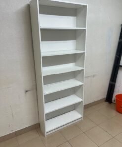 A white bookcase that looks similar to an IKEA BILLY bookcase or other comparable multi-shelf storage units. - Image 2