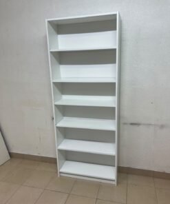 A white bookcase that looks similar to an IKEA BILLY bookcase or other comparable multi-shelf storage units. - Image 3