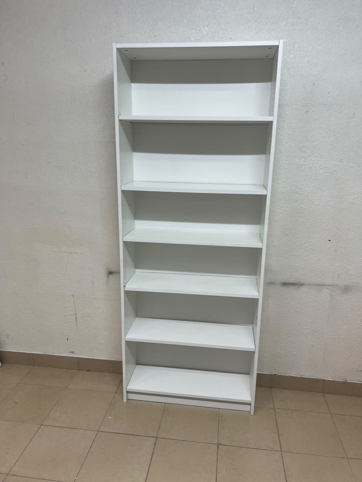 A white bookcase that looks similar to an IKEA BILLY bookcase or other comparable multi-shelf storage units. - Image 4