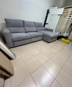 A grey L-shaped sofa bed with a high backrest and recliner seat, which closely matches the IKEA ESKILSTUNA model. Includes storage.