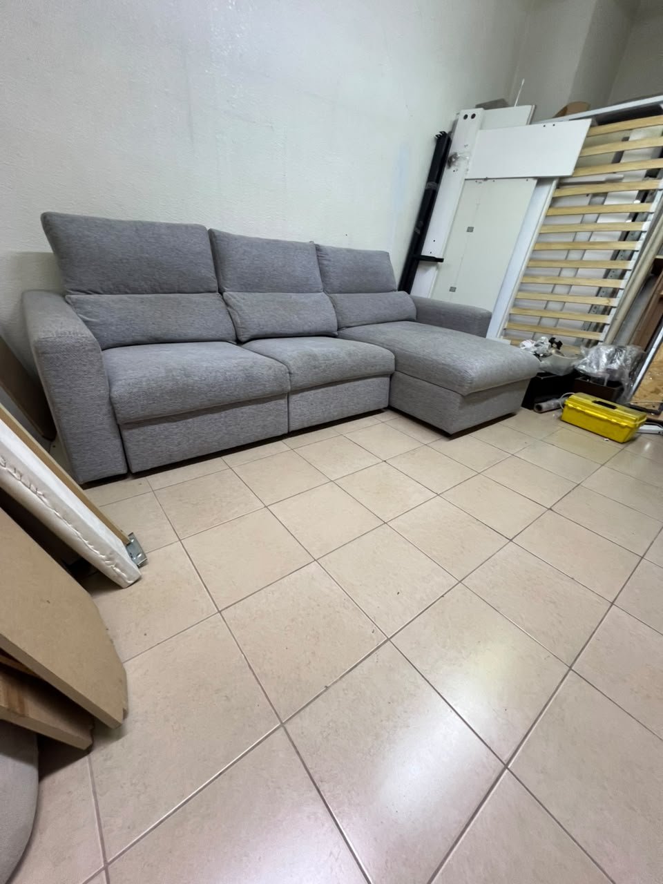 A grey L-shaped sofa bed with a high backrest and recliner seat, which closely matches the IKEA ESKILSTUNA model. Includes storage.