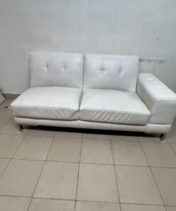 A white faux-leather sofa with a modern design, featuring button-tufted back cushions and slender metal legs. - Image 2