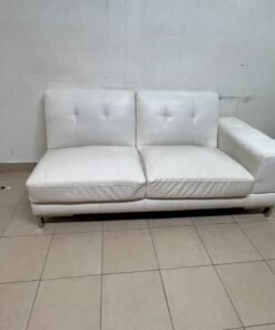 A white faux-leather sofa with a modern design, featuring button-tufted back cushions and slender metal legs. - Image 6