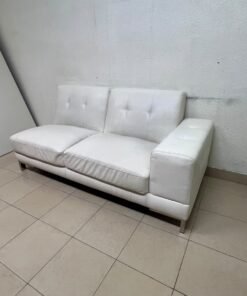 A white faux-leather sofa with a modern design, featuring button-tufted back cushions and slender metal legs. - Image 9