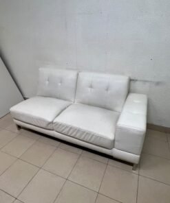 A white faux-leather sofa with a modern design, featuring button-tufted back cushions and slender metal legs. - Image 4
